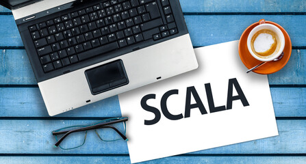 Scala programming language. Word Scala on paper and laptop