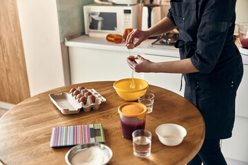 young beautiful mixed race woman is preparing marshmallow at light modern kitchen home