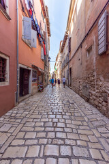 Fototapeta na wymiar Rovinj, Croatia - August 17 2019: Cobblestone street in the historic heart of Rovinj