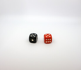 Red and black dice on a white background. Red and black dice shows five.	