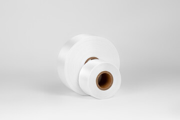 set of two coils of wide white satin ribbons for tags or decor, isolated on a white, gray background.
