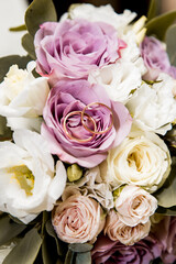 Bridal bouquet with purple and white flowers and rings