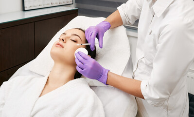Beauty injections into a beautiful woman face, smoothing of mimic wrinkles around the eyes using biorevitalization