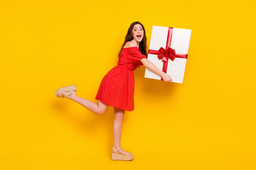 Full length profile photo of excited cheerful person hands hold heavy big giftbox isolated on yellow color background