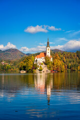 Obraz premium Famous alpine Bled lake (Blejsko jezero) in Slovenia, amazing autumn landscape. Scenic view of the lake, island with church, blue sky with clouds and reflection in the water, outdoor travel background