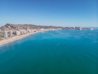 Fototapeta na wymiar Long urban sandy beach. Panoramic view of San Antonio beach in Cullera Valencia Spain