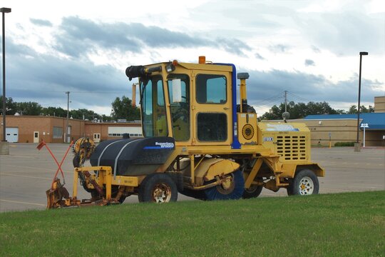 Superior Broom Parking Lot Sweeper Parked By A Nickerson Kansas School With Blue Sky And Green Grass That's Bright And Colorful.