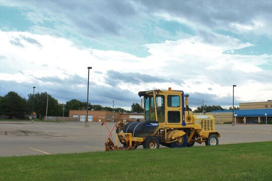 Superior Broom Parking Lot Sweeper Parked By A Nickerson Kansas School With Blue Sky And Green Grass That's Bright And Colorful.