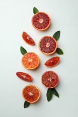 Red orange slices with leaves on white background, top view