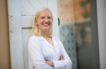 Portrait of smiling blond woman on street.