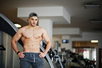 Fit and muscular arabian man posing in gym.