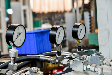 Pressure gauges on hydraulic oil station with high pressure transfer tubes.
