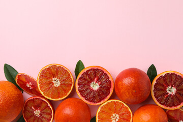 Red oranges and leaves on pink background