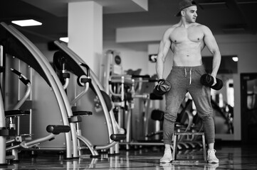 Fototapeta na wymiar Fit and muscular arabian man doing workouts in gym.