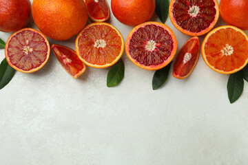 Red oranges and leaves on white textured background