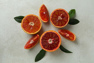 Red oranges and leaves on white textured background