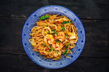 Top view on asian seafood wok udon noodles in a traditional bowl