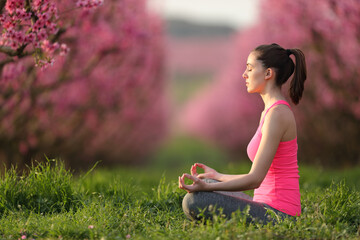 Profile of a yogi doing yoga in pink in a field