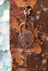 old padlock on a rusty door, seen in an abandoned school