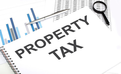 In the notebook, the text PROPERTY TAX , next to magnifier and pen, the background is graphics.
