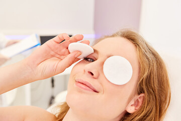 Junge Frau mit Wattepads auf den Augen