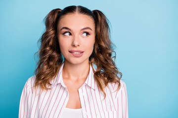 Photo portrait of curious dreamy girl looking empty space biting lip isolated vibrant blue color background