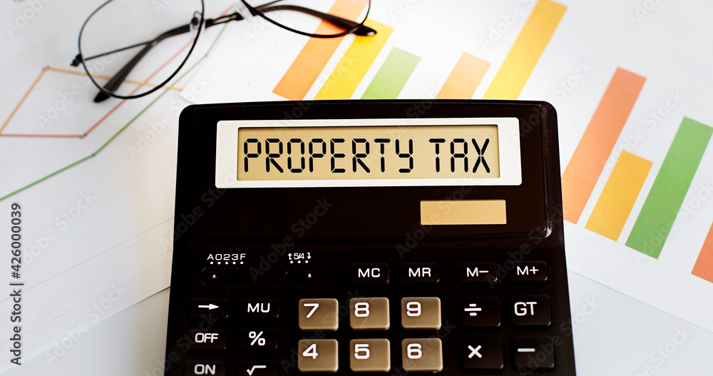 Poster calculator with the word property tax on the display with chart and glasses