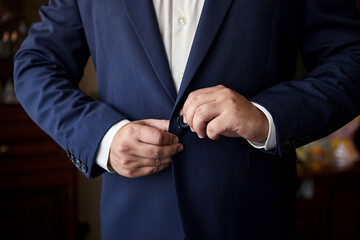 Businessman wears a jacket,male hands closeup,groom getting ready in the morning before wedding...