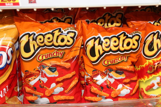 Crunchy Cheetos on a metal shelf shot closeup at a Dillons store in Hutchinson Kansas USA that's bright and colorful.