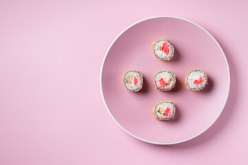 Sushi set in plate on pink background