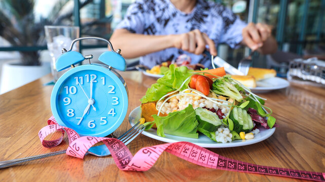 Selective focus of blue clock which Intermittent  fast program  concept  and  food for diet, fitness, plan, healthy eating image background