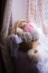 
Skeins of yarn in a wicker basket on the window Hobby