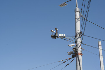 Video camera on a pole outside against a clear blue sky. Tracking system for citizens, face...