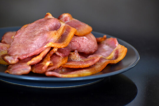 Back bacon on a blue plate. Selective focus.	
