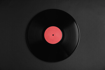 Vintage vinyl record on black background, top view