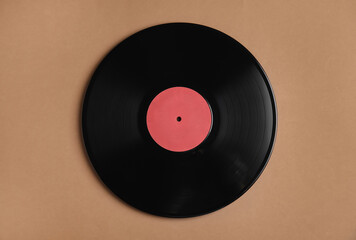 Vintage vinyl record on brown background, top view