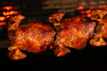Grilling whole chickens in rotisserie machine, closeup