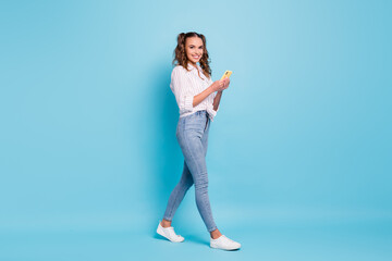 Full length body size profile side view of lovely teen cheerful girl using gadget 5g app going isolated on vivid blue color background