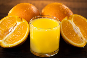 Orange juce, half of orange on the wooden table. Summer mood. close up shot. raw footage