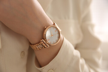 Woman with luxury wristwatch on light background, closeup - Powered by Adobe