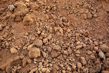 Close-up of the ground. Dry texture. Soil is a useful natural resource. Brown color or dark orange of clay. Construction sand material. Abstraction. Backdrop. Priming top view. Natural design mockup