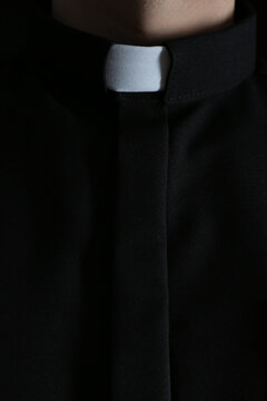 Priest wearing cassock with clerical collar, closeup view