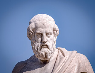 Plato, the ancient Greek philosopher white marble bust sculpture under blue sky background, space...
