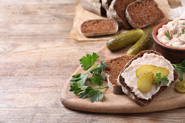 Sandwich with delicious lard spread and pickles on wooden table. Space for text