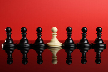 The concept of leadership, the white pawn piece stands out from the crowd of black