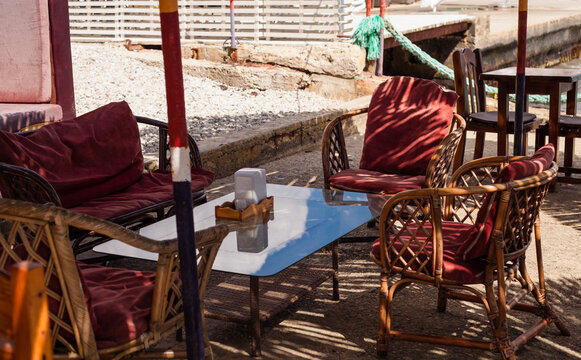 cafe by the sea, restaurant on the beach, thatched beach umbrellas, table, wicker swing chair, rocking chair. Crimean pier