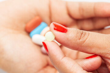 Macro Close up of medicinal or herbal multi-color tablet, capsule, and pill on a female hand palm. Top view,