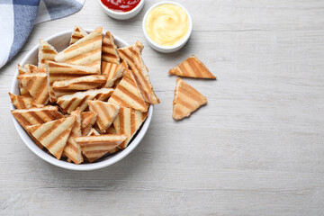 Delicious pita chips on white wooden table, flat lay. Space for text