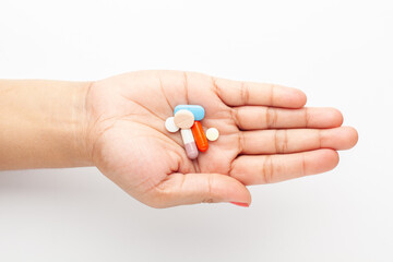 Macro Close up of medicinal or herbal multi-color tablet, capsule, and pill on a female hand palm. Top view,