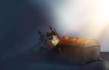 low key image of beautiful queen or king crown over gold treasure chest. vintage filtered. fantasy...